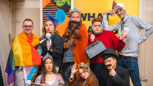 The cast of 'SCOTS' posing in costumes, smiling at the camera. 