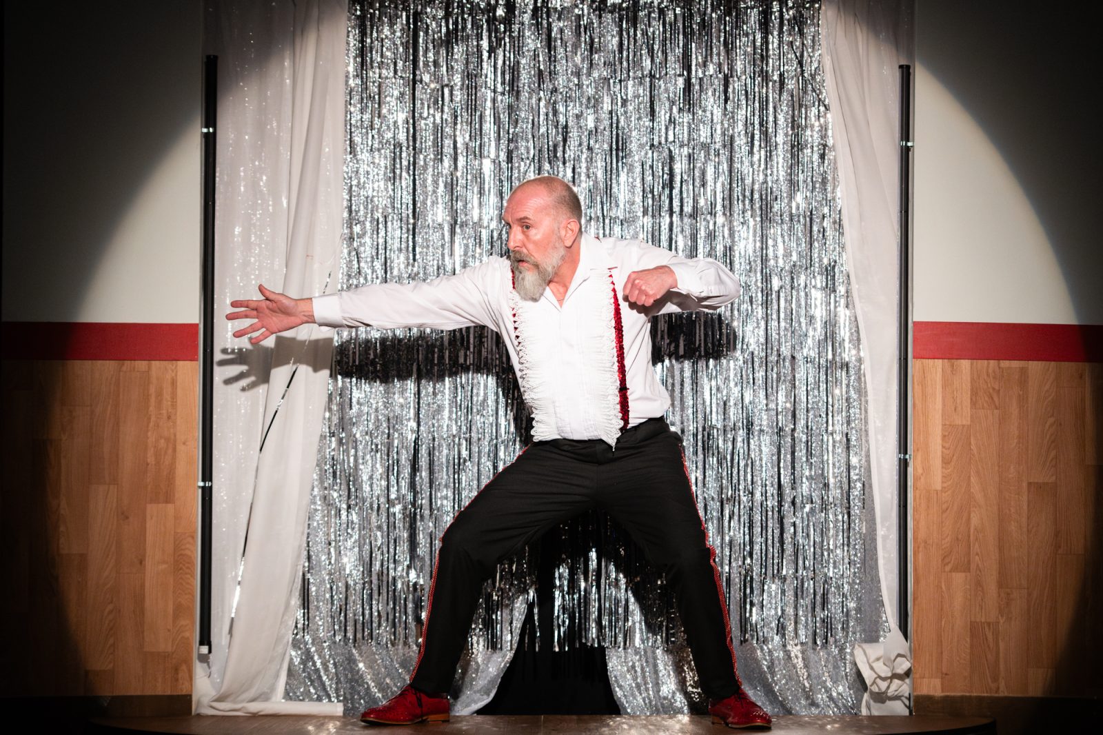 Stephen Docherty on stage wearing bright red dancing shoes.