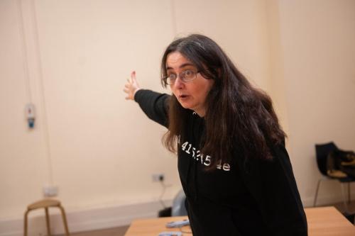 Karen Bartke in rehearsals, pointing away angrily. 